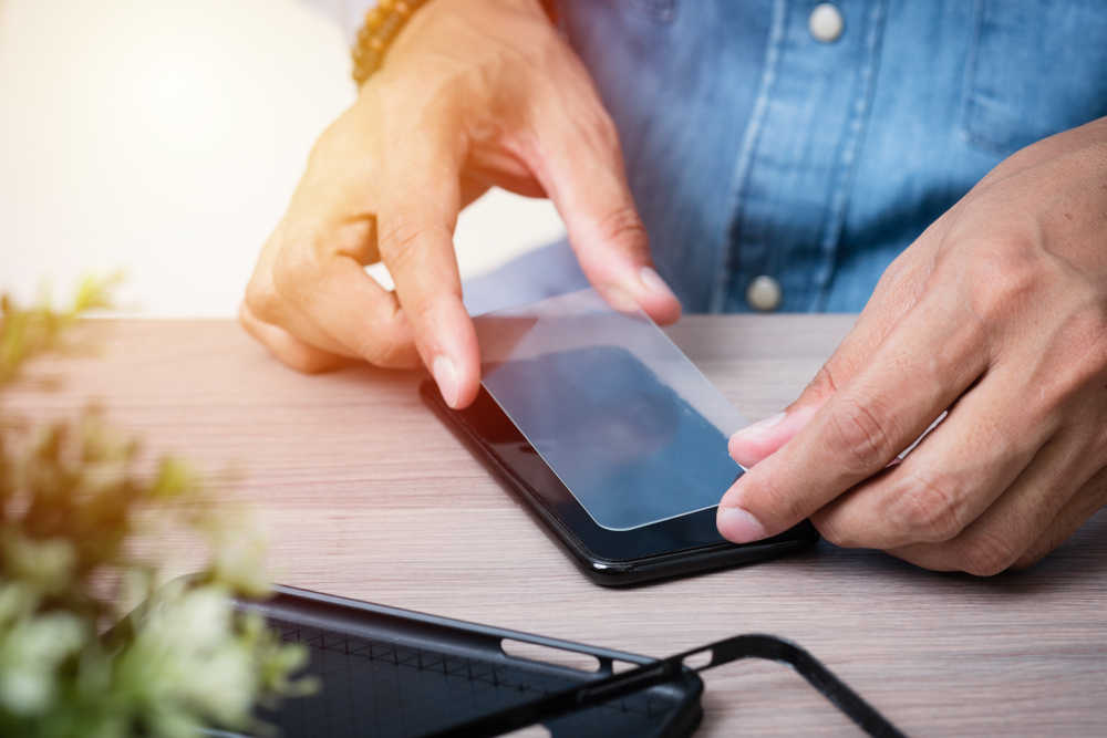 The man replacing the broken tempered glass screen protector for smartphone Nor Gals.jpg