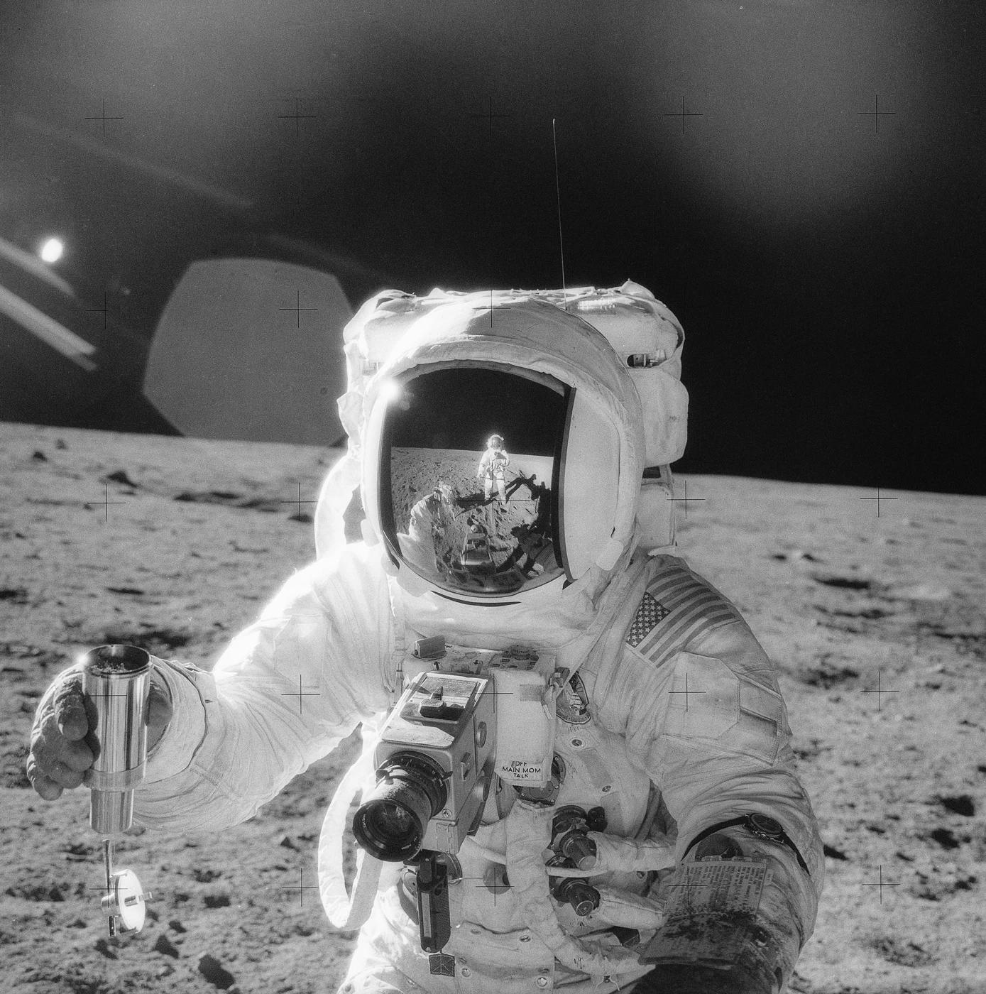 Could Moon Dust Hold Traces of Alien Technology? What Scientists Propose—and Haven’t Found 2 Apollo 12 astronaut holding a lunar soil sample container on the Moon, with another astronaut reflected in the visor